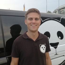 Rene von Panda Parken vor einem Panda Shuttle